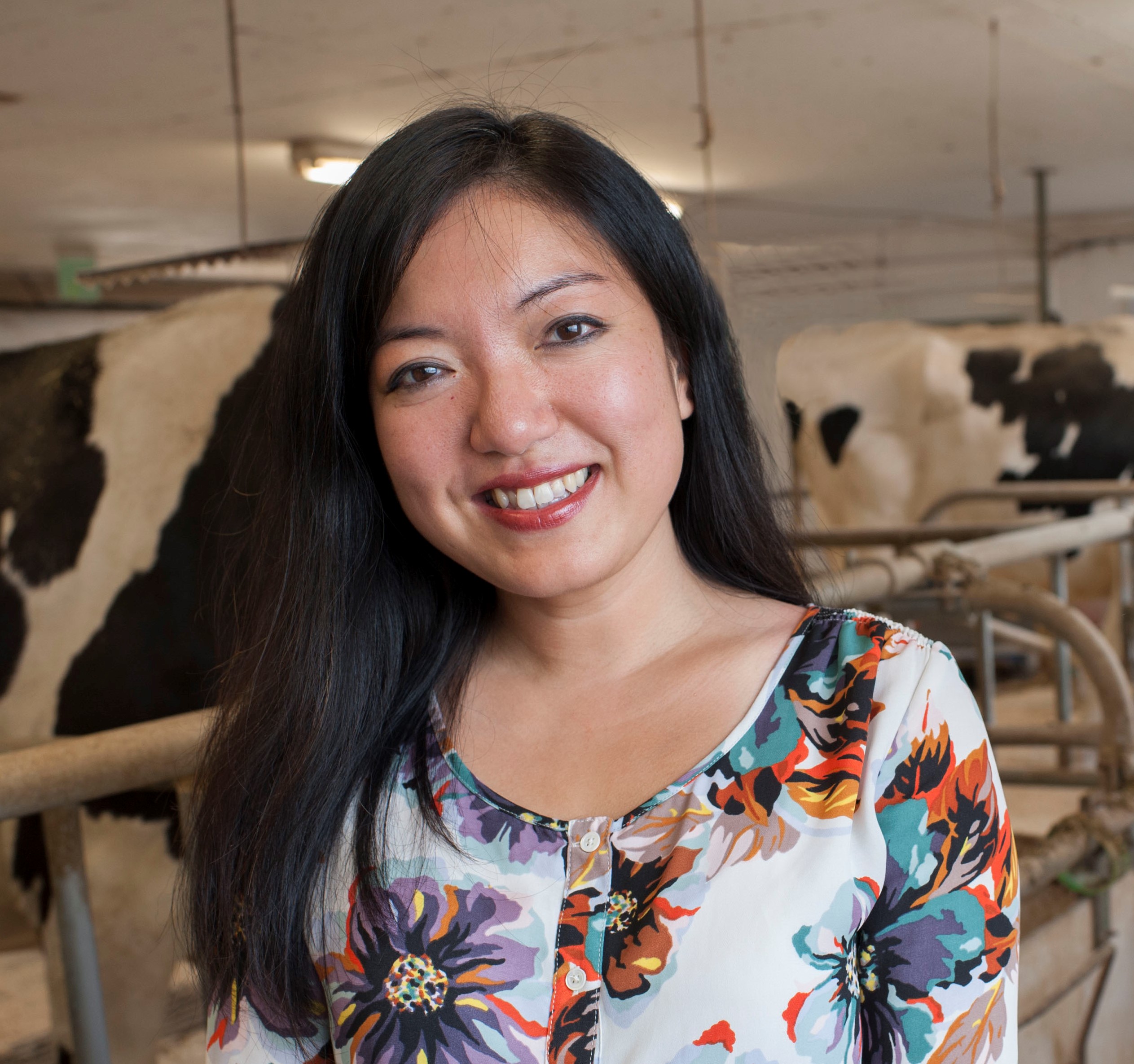 Headshot of Felicia Wu with cows in the background